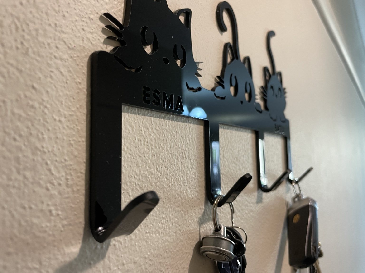 Angled close-up of heat-bent hooks on a custom acrylic key holder