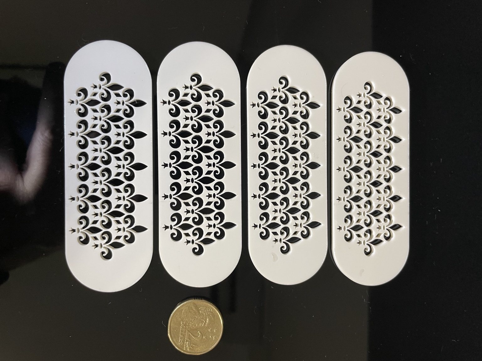 Four narrow decorative 3 millimetre acrylic components with fine internal laser-cut detail