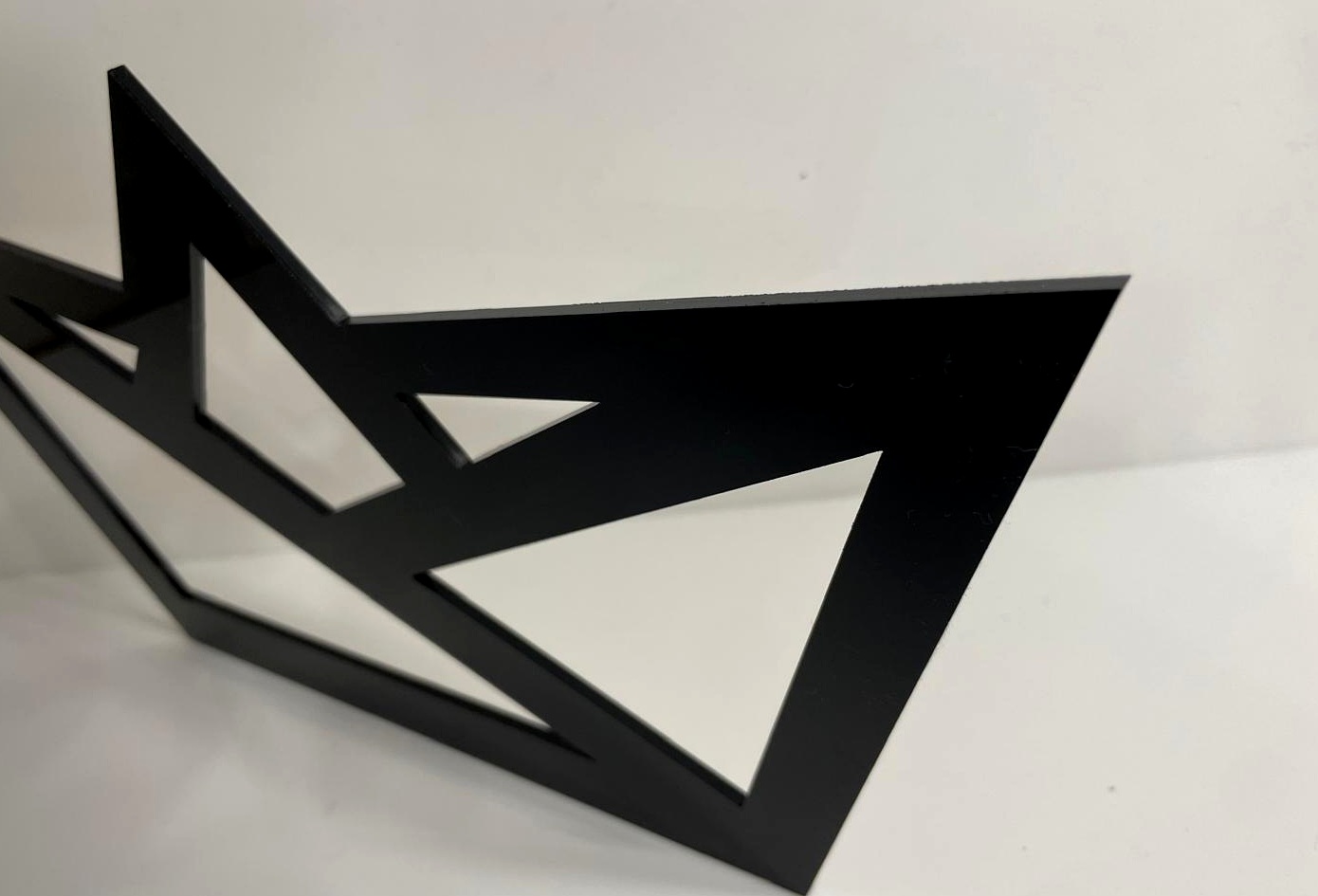 Black acrylic logo sign detail showing crisp cut edges