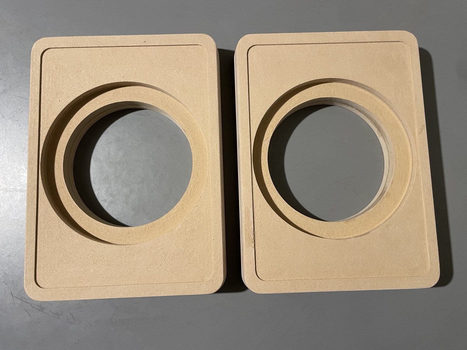 Two completed CNC-routed laminated MDF speaker enclosure panels
