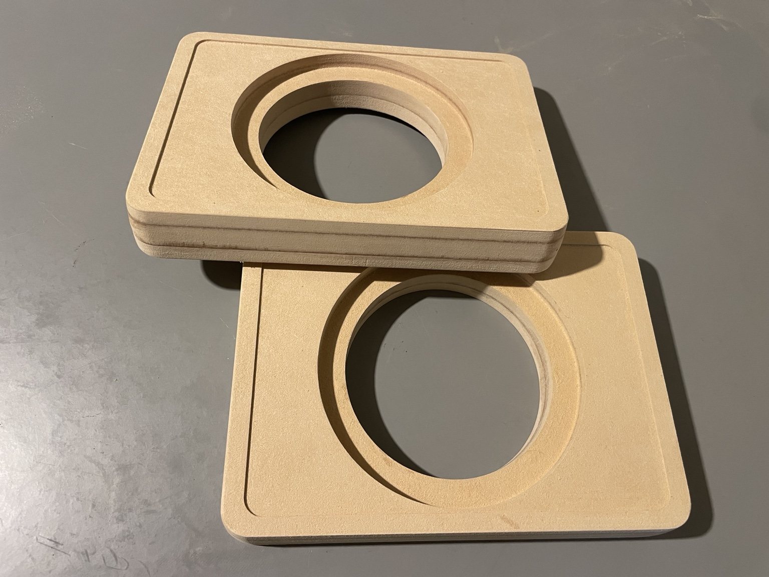 Stacked MDF speaker enclosure panels showing laminated construction